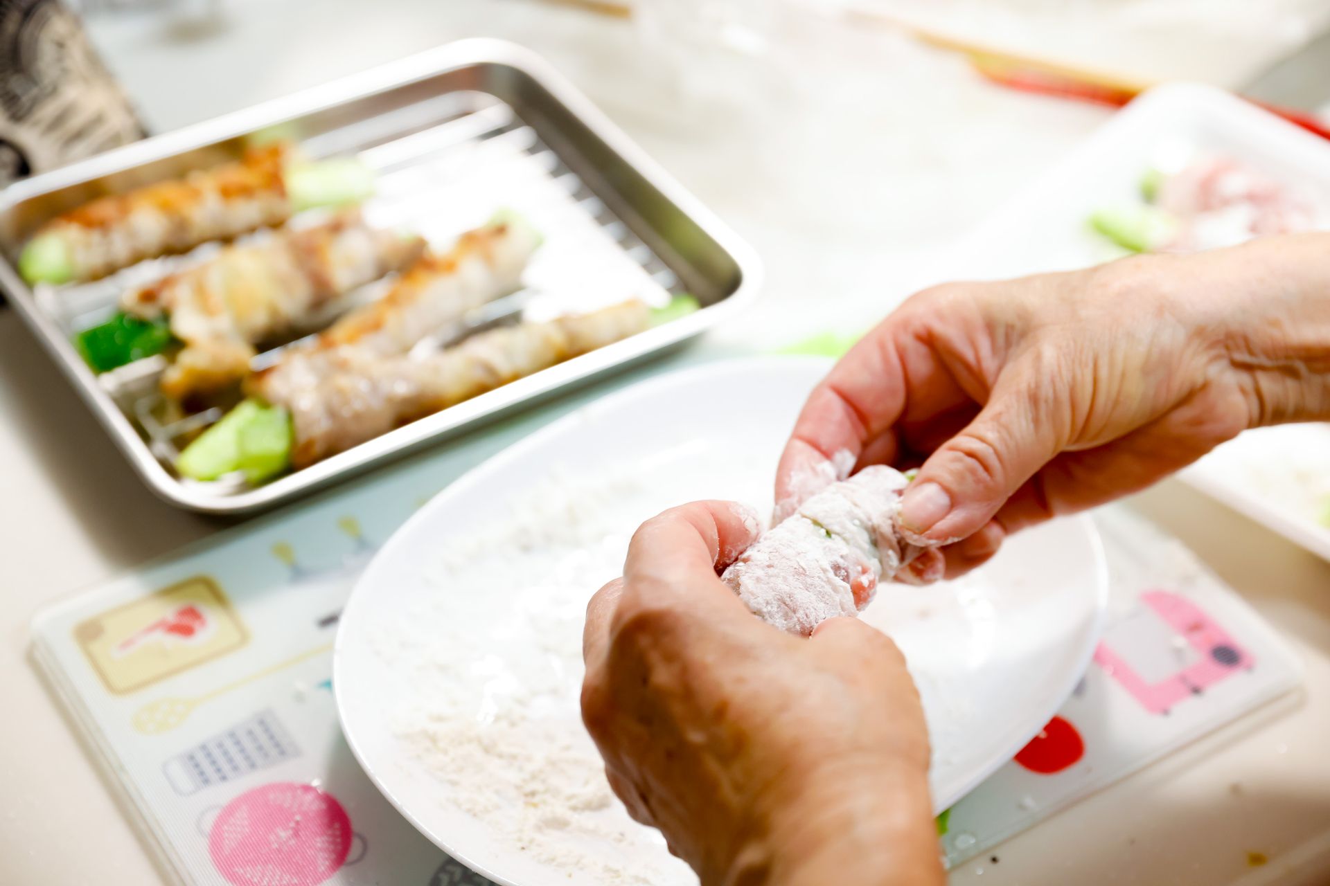 肉巻きに小麦粉をまぶす様子